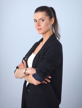 ayakta, gri arka plan üzerinde izole genç kadın