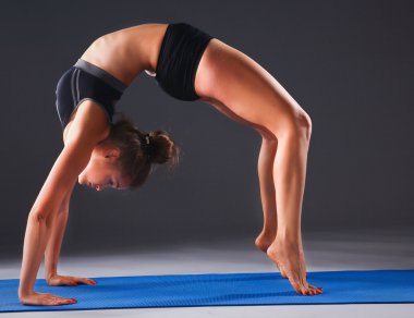 Mat Yoga egzersiz yaparak genç bir kadın