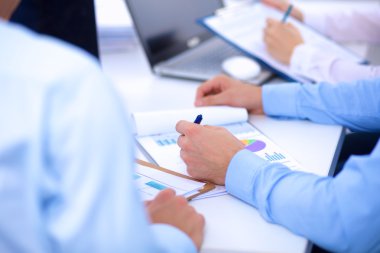 İş toplantılarında, ofiste oturan ve yazan iş adamları.