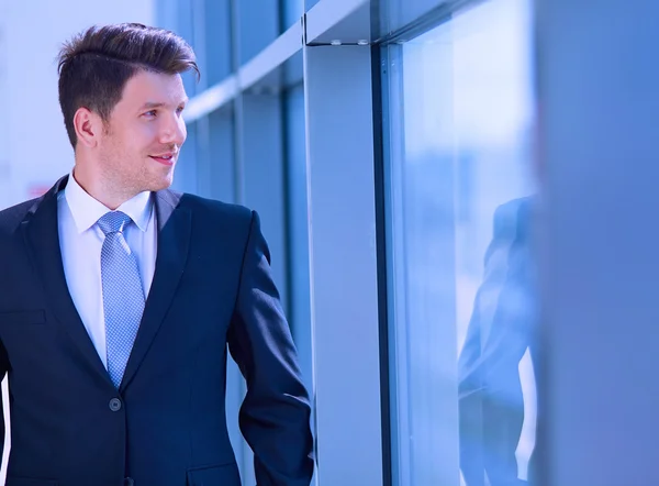 Portret van een zakenman in de buurt van een raam in het kantoor — Stockfoto