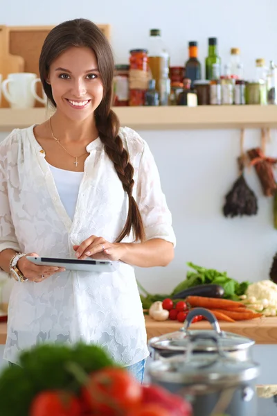 Mujer joven usando una tableta para cocinar en su cocina —  Fotos de Stock