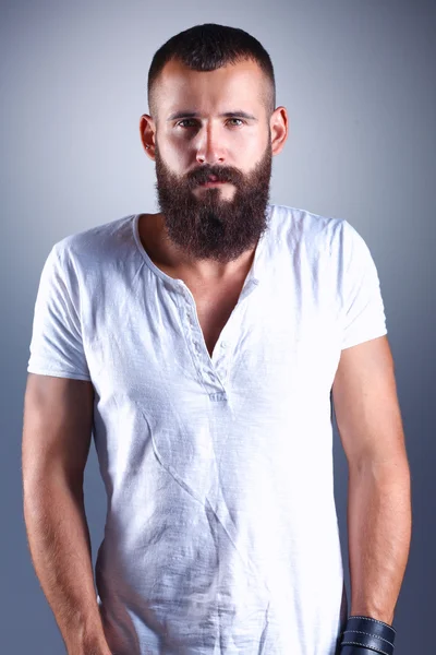 Портрет красивого бородатого мужчины, стоящего, изолированного на сером фоне — стоковое фото