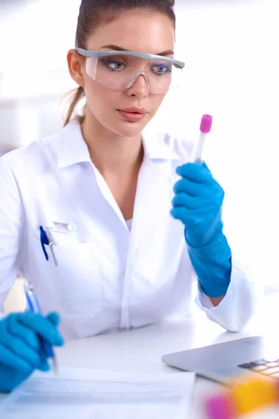 Woman researcher is surrounded by medical vials and flasks, isolated on white background — Stock Photo, Image