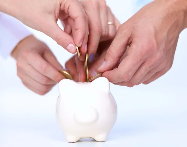 People putting coin into the piggy bank — Stock Photo, Image