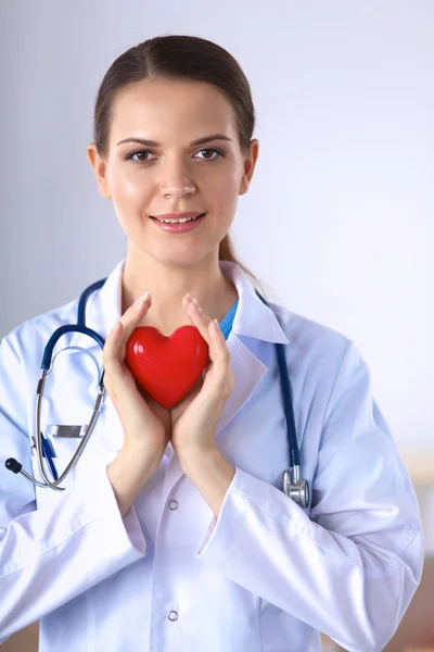 Νεαρή γυναίκα γιατρός κρατώντας μια κόκκινη καρδιά — Φωτογραφία Αρχείου