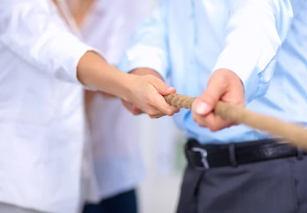 Konzeptbild eines Geschäftsteams, das ein Seil als Element der Teamarbeit im Vordergrund verwendet — Stockfoto