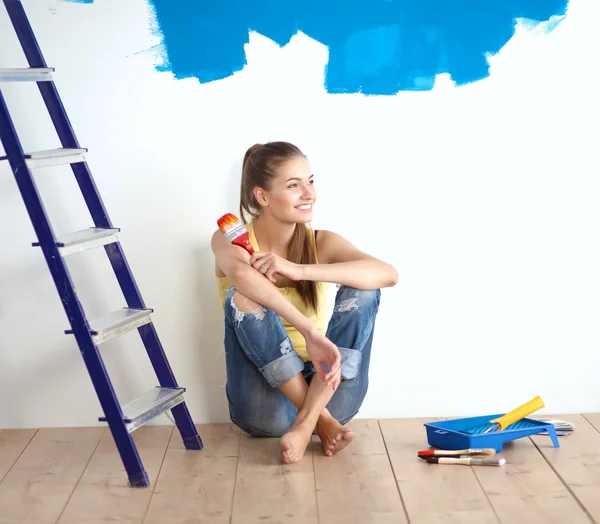 Retrato de pintora sentada en el suelo cerca de la pared después de pintar . — Foto de Stock