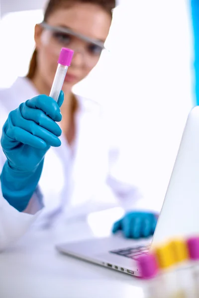 Woman researcher is surrounded by medical vials and flasks, isolated on white background — Stock Photo, Image