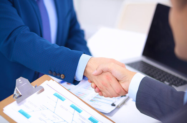 Деловые люди пожимают друг другу руки, заканчивают встречу