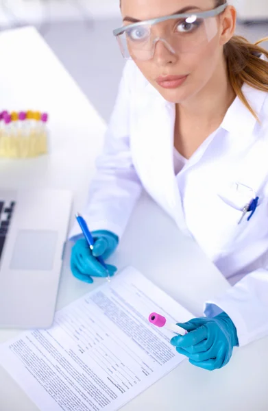 Woman researcher is surrounded by medical vials and flasks, isolated on white background — Stock Photo, Image