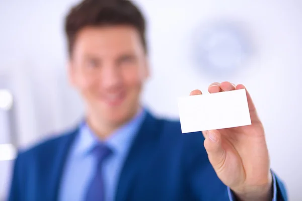 Retrato de un joven sosteniendo una tarjeta blanca en blanco — Foto de Stock