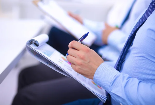 Uomini d'affari seduti e che scrivono alla riunione di lavoro, in ufficio — Foto Stock