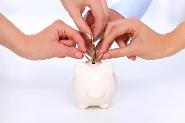 Mensen brengen munt in de piggy bank — Stockfoto