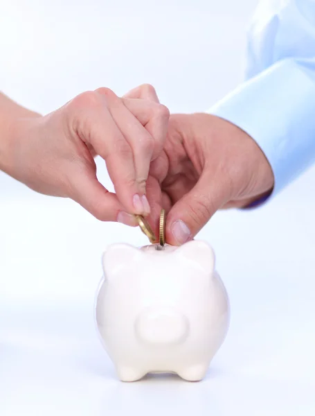 People putting coin into the piggy bank — Stock Photo, Image