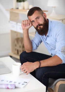 Genç işadamı koltukta oturuyor.