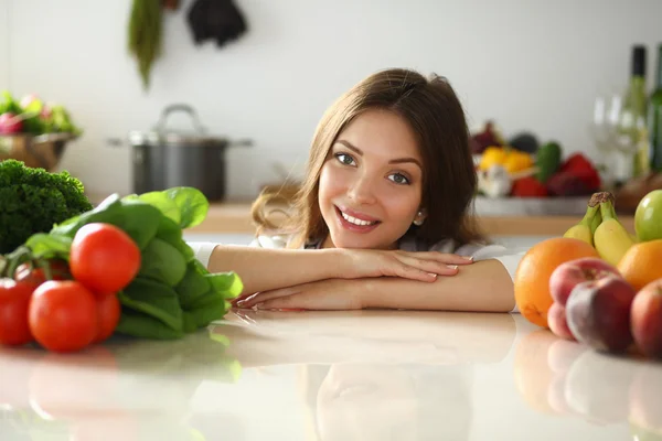 Jonge vrouw in de buurt van bureau in de keuken . — Stockfoto