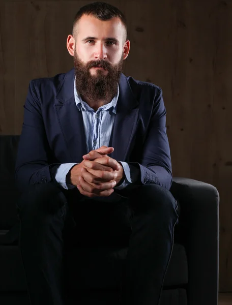 Geschäftsmann auf dem Sofa in der Büro-Lobby, isoliert auf dunklem Hintergrund — Stockfoto