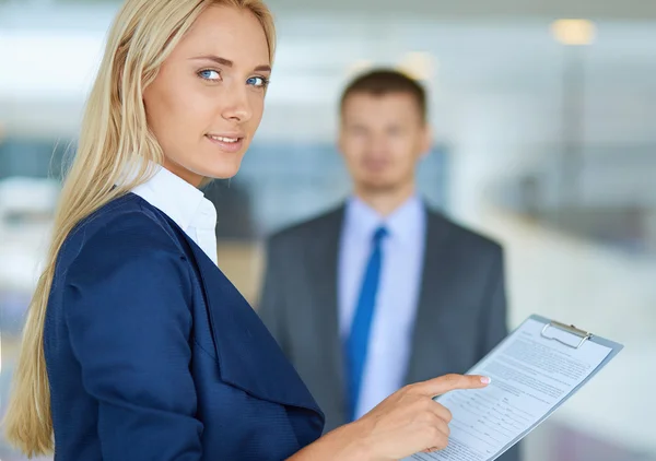 Zakenvrouw permanent in office, documenten in de hand houden — Stockfoto