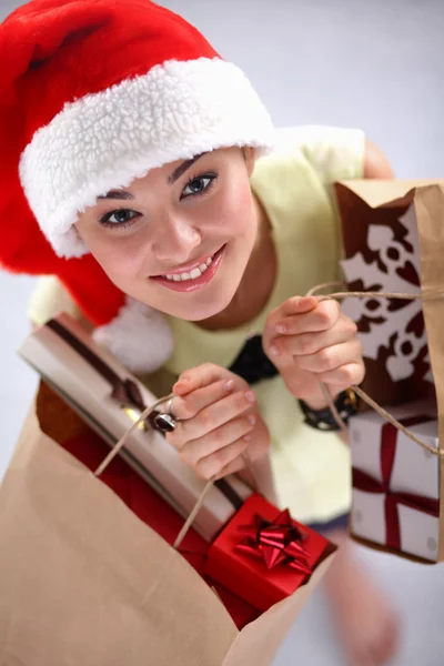 Šťastná dívka na santa hat s krabičky na červeném pozadí — Stock fotografie