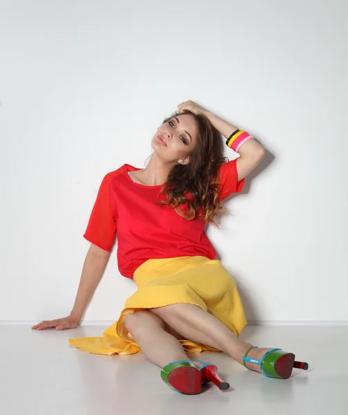 Young woman sitting on the floor, isolated in white background — Stock Photo, Image