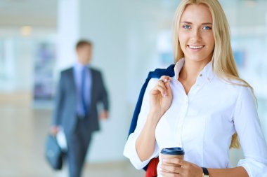 Yound kadın ayakta ofisindeki kahve içmek