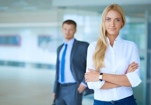 Portrait of young businesswoman in office with colleagues in the background — Stock Photo, Image