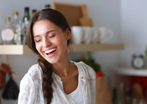 Jovem mulher de pé perto da mesa na cozinha — Fotografia de Stock