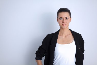 ayakta, gri arka plan üzerinde izole genç kadın