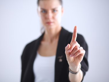 Kadın parmaklarıyla hayali bir ekrana dokunuyor.