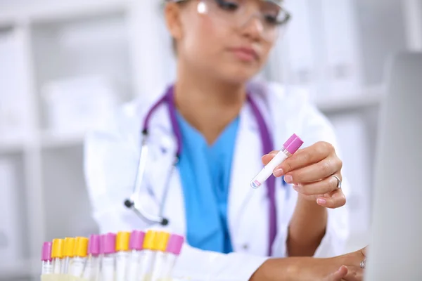 Mulher pesquisadora é cercada por frascos e frascos médicos, isolados em fundo branco — Fotografia de Stock