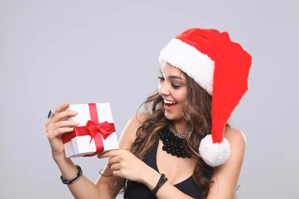 Noel Baba şapkası hediyeler, gri izole tutan kadın — Stok fotoğraf