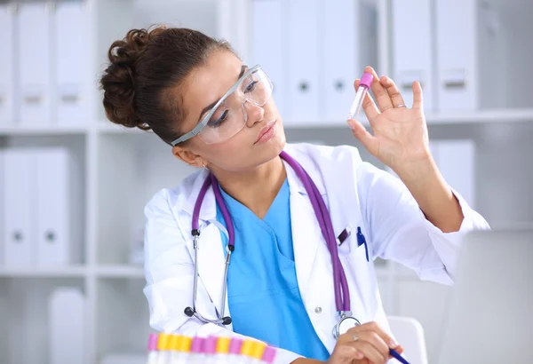 Woman researcher is surrounded by medical vials and flasks, isolated on white background — Stock Photo, Image