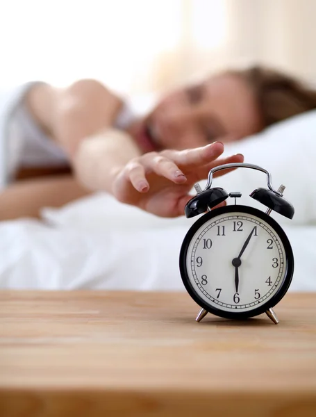 Young sleeping woman and alarm clock in bedroom at home — Stock Photo, Image