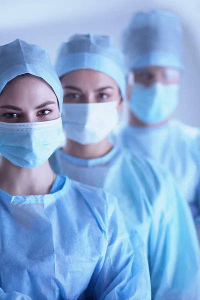 Surgeons team, wearing protective uniforms,caps and masks — Stock Photo, Image