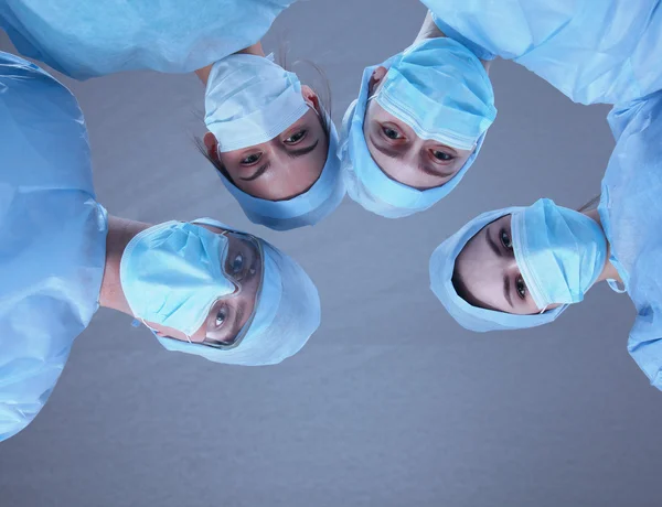 Equipe de cirurgiões, usando uniformes protetores, bonés e máscaras — Fotografia de Stock
