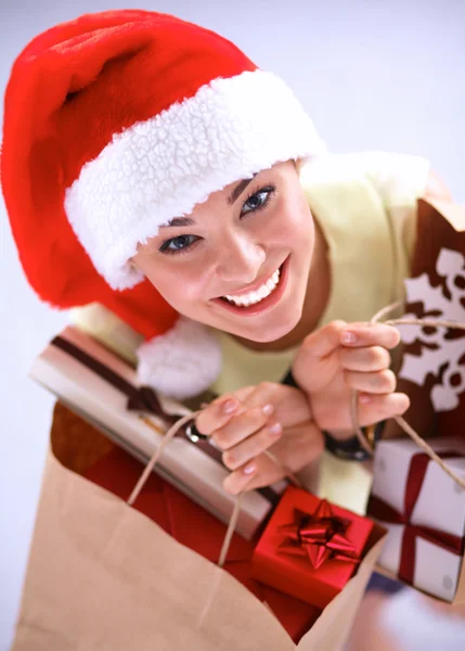Happy girl on santa hat with gift box on red background — Stock Photo, Image