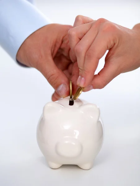 People putting coin into the piggy bank — Stock Photo, Image