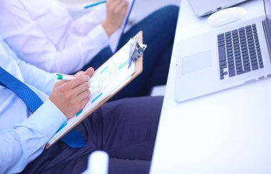 İş toplantılarında, ofiste oturan ve yazan iş adamları.