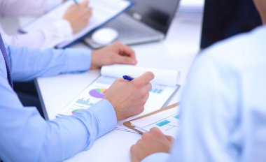 İş toplantılarında, ofiste oturan ve yazan iş adamları.