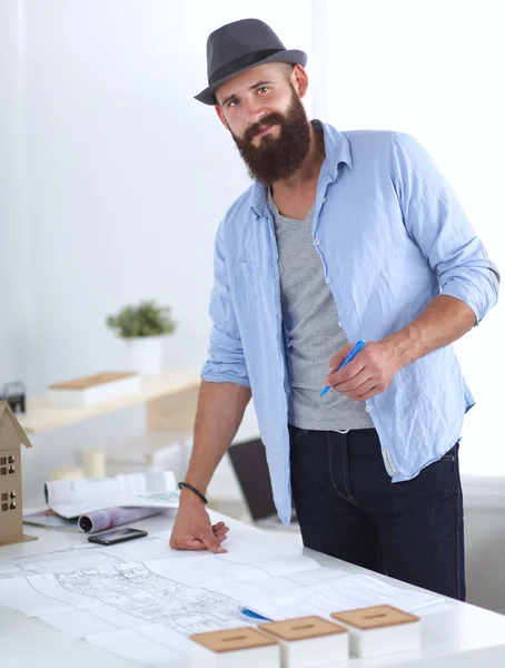 Retrato de diseñador masculino en sombrero con planos en el escritorio —  Fotos de Stock