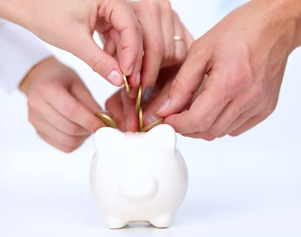 People putting coin into the piggy bank — Stock Photo, Image