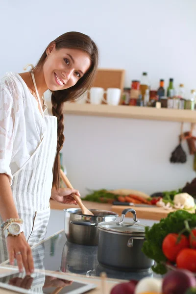 Cozinhar mulher na cozinha com colher de madeira — Fotografia de Stock