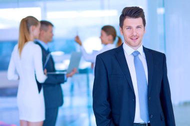 arka planda meslektaşları ile Office genç işadamı portresi