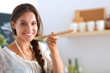 Mutfakta ahşap kaşıkla yemek pişiren kadın