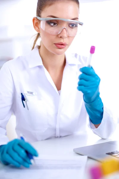 Woman researcher is surrounded by medical vials and flasks, isolated on white background — Stock Photo, Image