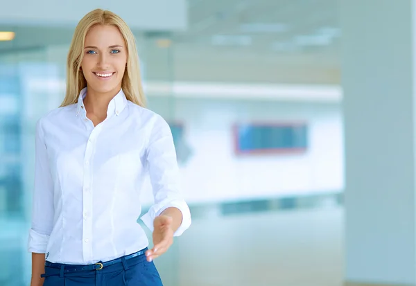 Jovem mulher de negócios pronta para aperto de mão de pé no escritório — Fotografia de Stock