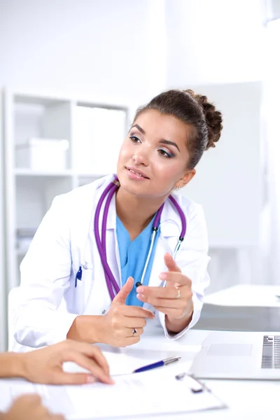 Жінка-лікар сидить на столі і працює ноутбуком в лікарні — стокове фото