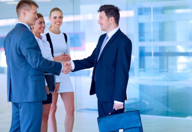 İki başarılı iş adamının el sıkışırken tam boy görüntüsü.