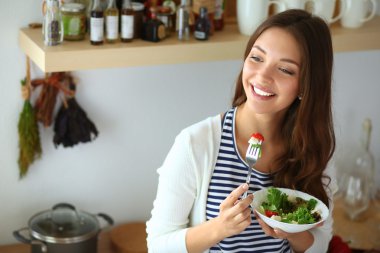 Salata yemek ve karışık salata tutan genç kadın
