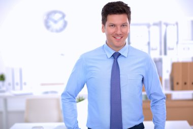 Ofiste masasının karşısında duran bir iş adamı ya da yönetici.